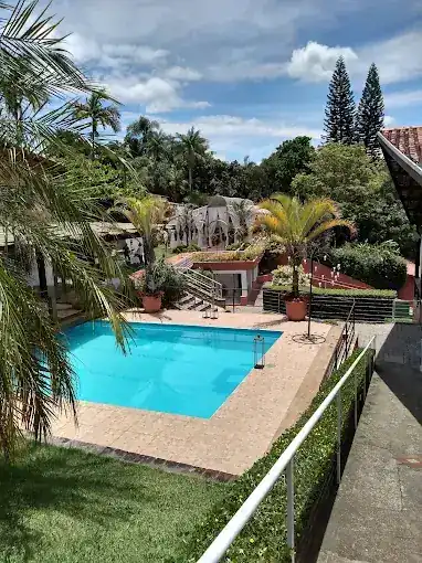 Salão do Espaço Recanto do Sol com mesas postas e janelas para o jardim